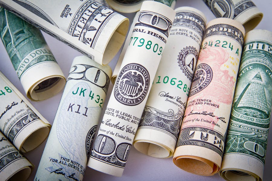Billetes de dólar enrollados sobre una superficie clara